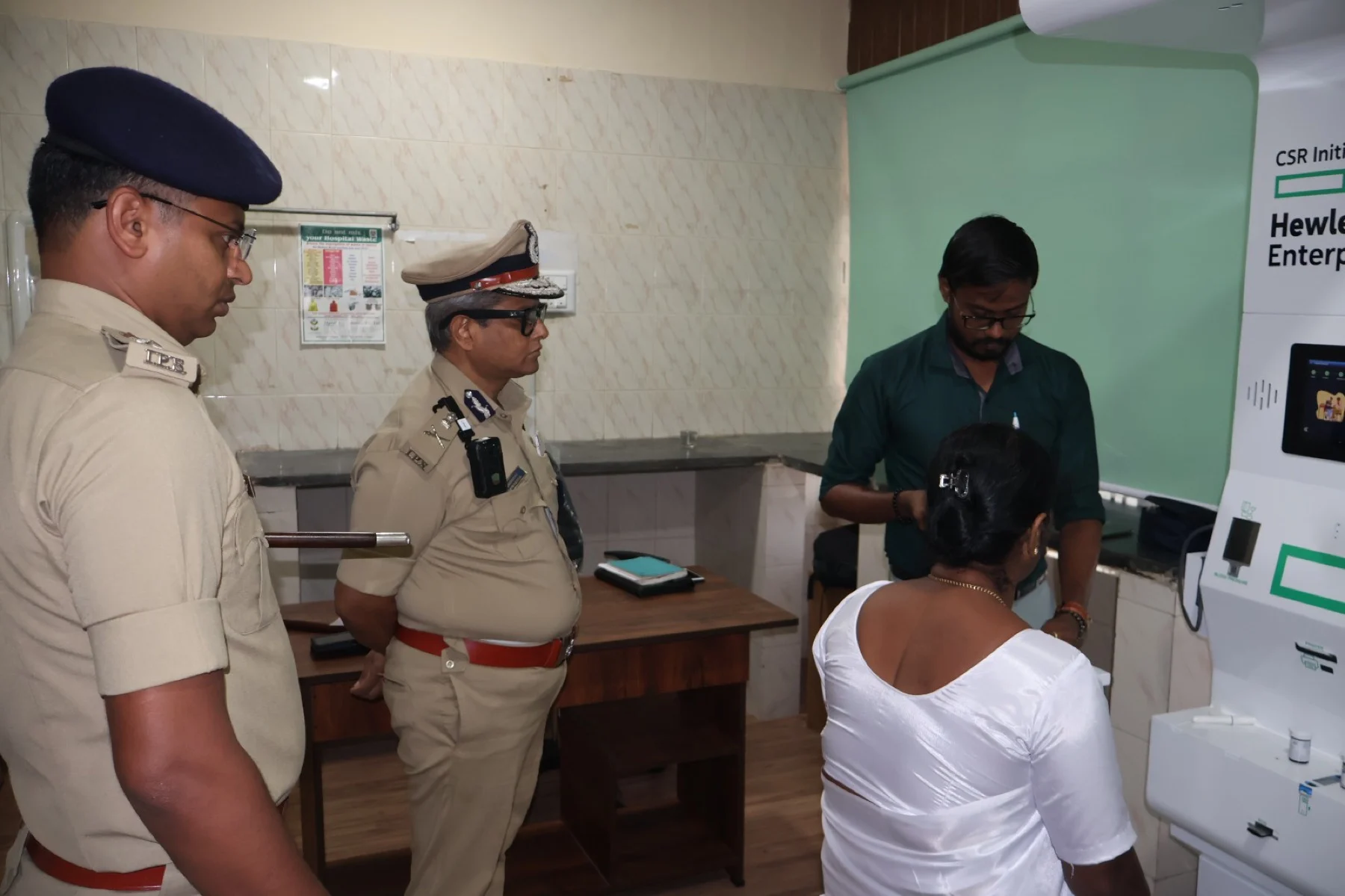 Health kiosk deployment in Karnataka under a CSR initiative, with police officials reviewing community screening use