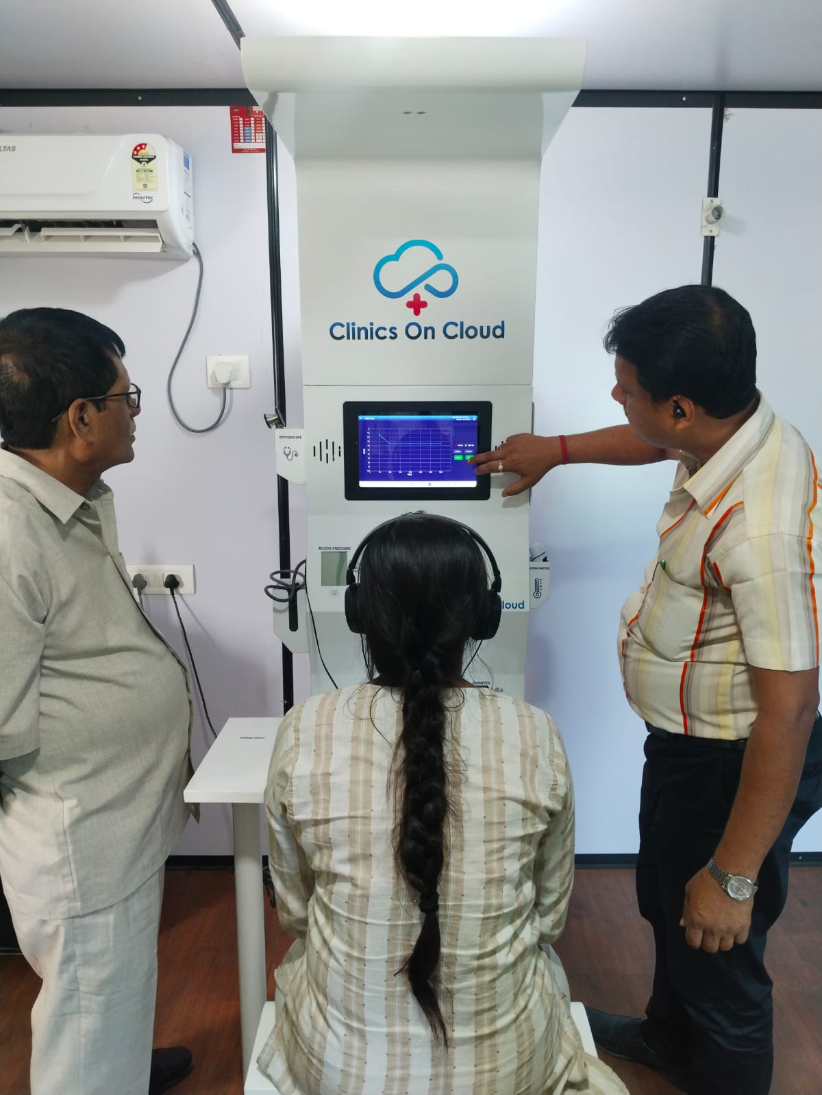 Health kiosk deployment in West Bengal, showing a patient screening with vitals monitored on-screen