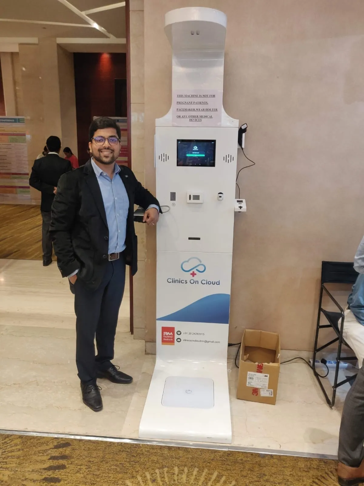 A Clinics On Cloud health kiosk with weighing platform on display at a trade exhibition