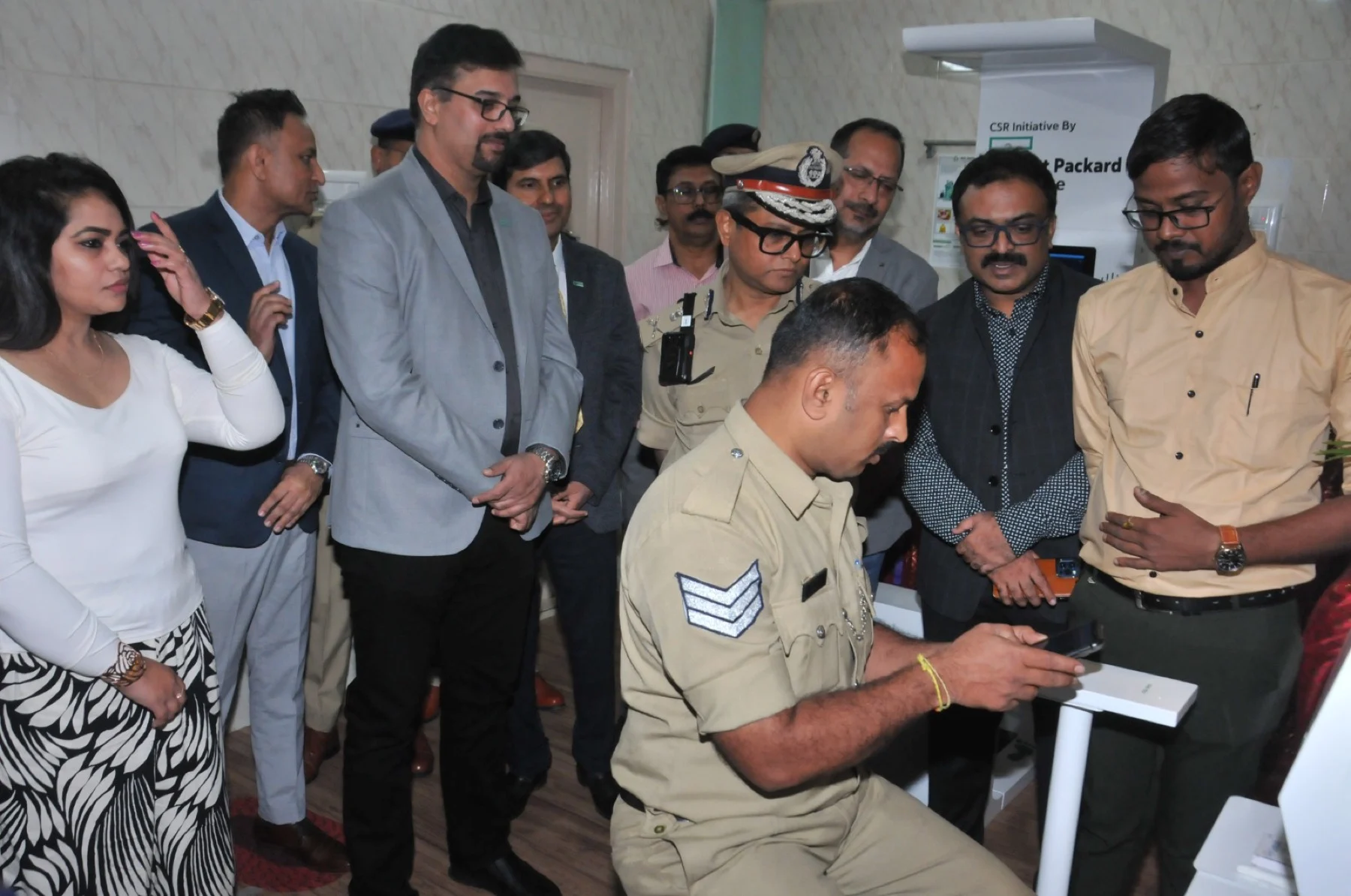 Police officer trials health kiosk device during CSR launch for police force health screening programme