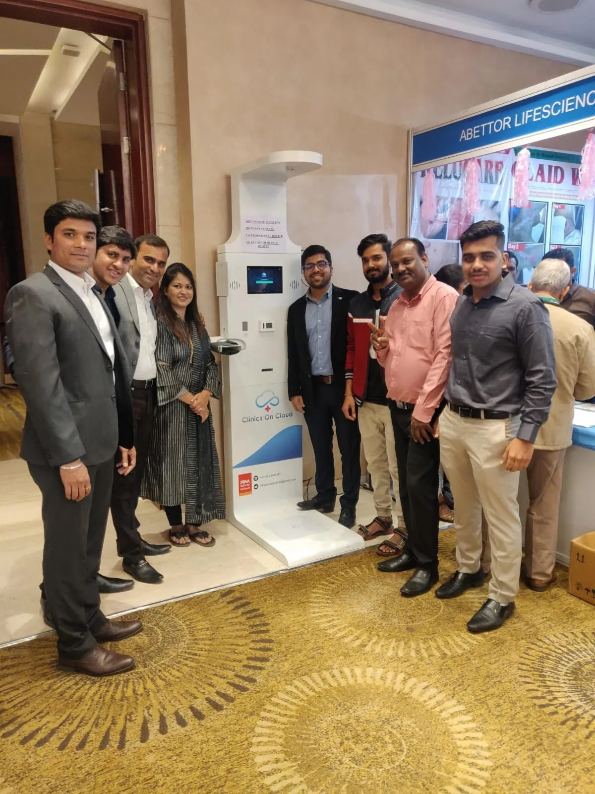 Clinics On Cloud team showcasing a health kiosk at a medical exhibition event